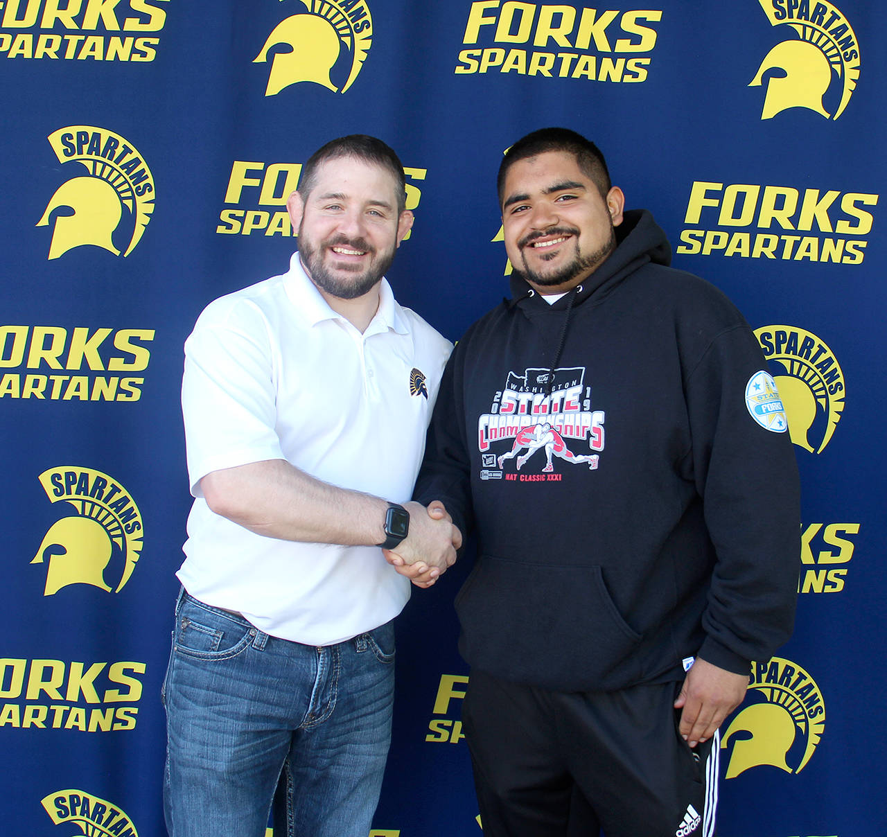 Forks’ Eden Ciseneros, right, is congratulated by Forks athletic director Kyle Weakley, after being awarded the Dick Grabenhorst Memorial Scholarship. Cisneros, a senior who plans to attend Pacific Lutheran University, played football, placed sixth at the state wrestling meet and was on the Spartans’ state soccer team this school year.                                Christi Baron/Olympic Peninsula News Group