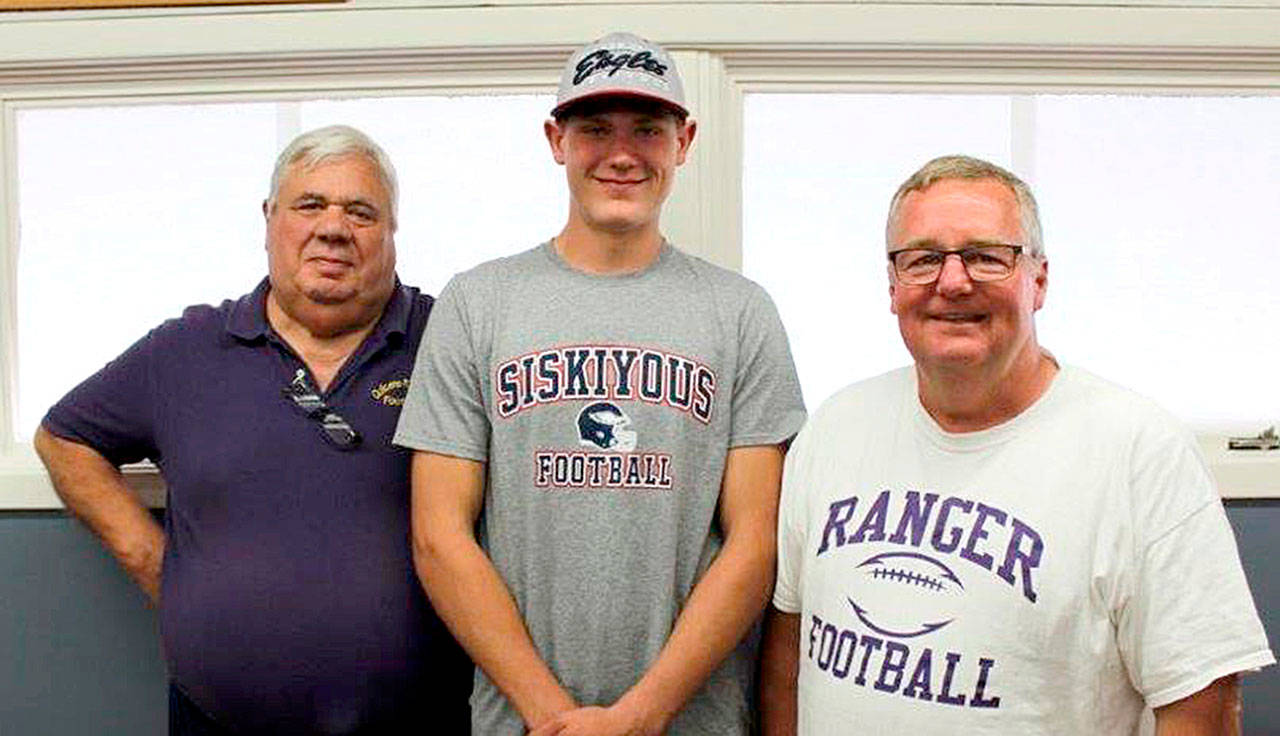 From left, Byron Wilson, Quilcene assistant head football coach Byron Wilson, Robert Comstock III and head football coach Trey Beathard were at Comstocks signing last week to play football at College of the Siskiyous in Weed, Calif.