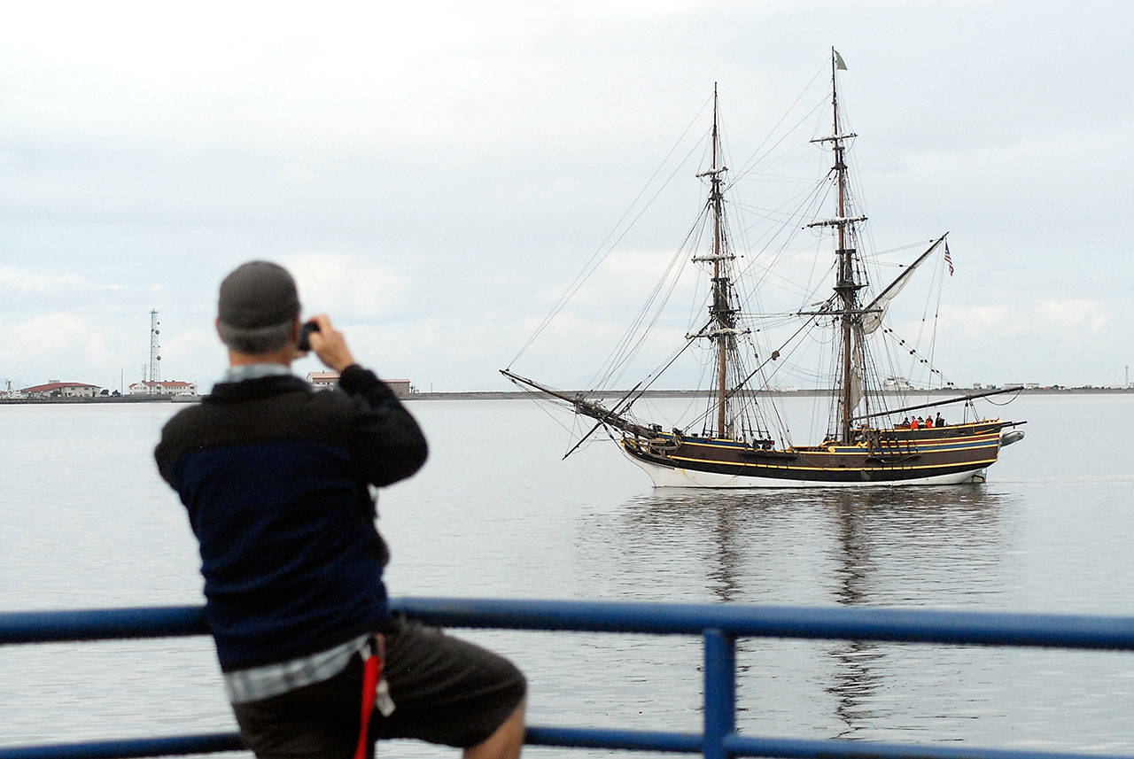 Christopher Thomsen of Port Angeles takes a photo of the tall ship Lady Washington as it does a beauty pass of City Pier after arriving in Port Angeles on Thursday. (Keith Thorpe/Peninsula Daily News)