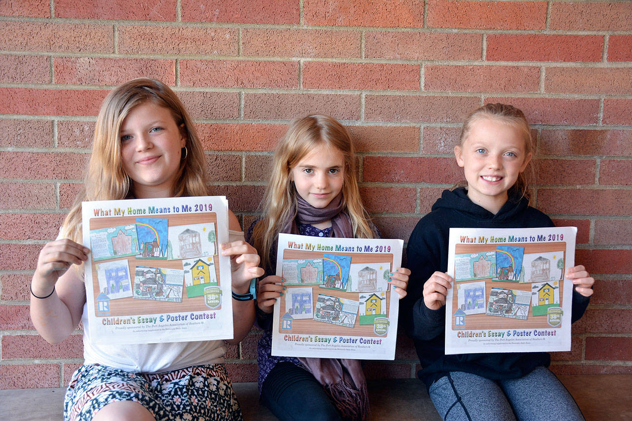 Contest grand-prize winners display their posters, from left, Dylann Christensen, Stella Fradkin and Layla Parker. (Patsene Dashiell/Port Angeles School District)