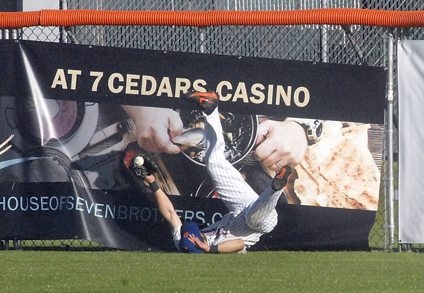 <strong>Keith Thorpe</strong>/Peninsula Daily News                                Lefties centerfielder Ronnie Rust tumbles to the ground after crashing into the fence fielding a long fly ball in the second inning against the Bellingham Bells on Friday at Port Angeles Civic Field.