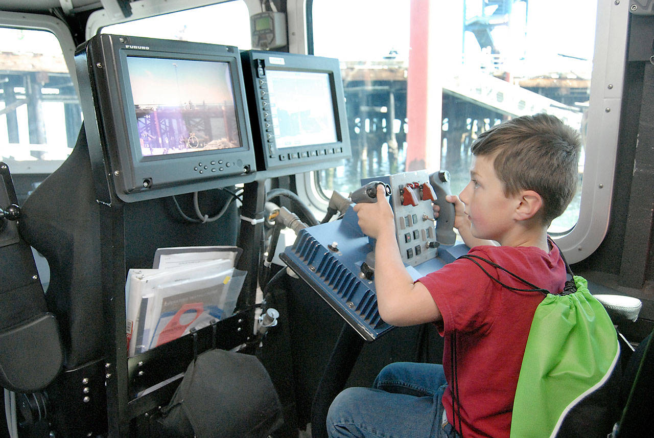 Hayden Huffman, 5, of Port Angeles operates a remote-controlled camera aboard a U.S. Coast Guard 64-foot special purpose craft-screening vessel during a tour of the boat on Saturday at the Port Angeles Maritime Festival at Port Angeles City Pier. The event, organized by the Port Angeles Regional Chamber of Commerce, featured a variety of ships, boats and watercrafe, as well as nautical-themed displays and activities. The festival continues today with free admission to most activities. (Keith Thorpe/Peninsula Daily News)