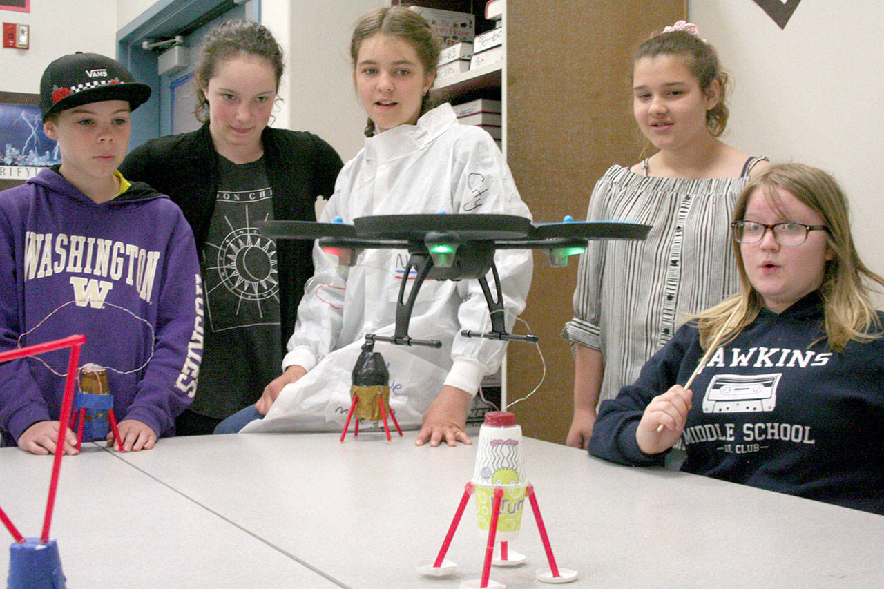 From left, Milo Queen, Tallulah Sebastian, Claire Porter, Alita Aldana and Zoey Ware, sixth-graders from Blue Heron Middle School in Port Townsend, attempt to pick up their makeshift lunar landing module by piloting a drone. (Brian McLean/Peninsula Daily News)