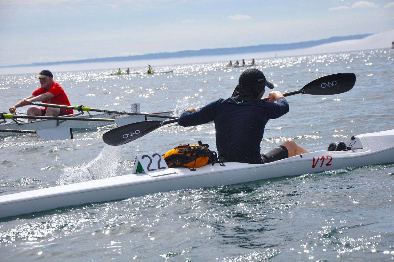 Roger Lamb, right, competes in an Epic V12 surf ski during the 2013 Rat Island Regatta, closely followed by Jim Buckley, left, riding in the “Dosewallips,” a quadruple skull boat from the Rat Island Rowing and Sculling Club. (Michael Lampi)