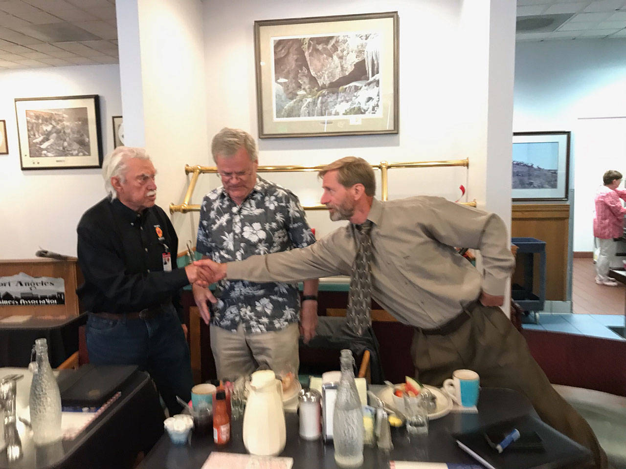 Clallam County Fire District 2 commissioner candidate Keith Cortner, right, shakes hands with incumbent Richard Ruud after a PABA primary election voter forum Tuesday that included challenger Steve Hopf, center. (Paul Gottlieb/Peninsula Daily News)