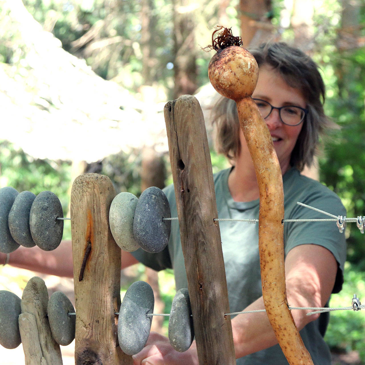 Clea Rome of Port Angeles begins installation of her sculpture, “Abacus,” in Webster’s Woods earlier this week. The large piece is among several added to the park for the Solstice Art Festival this Friday and Saturday. (Port Angeles Fine Arts Center)