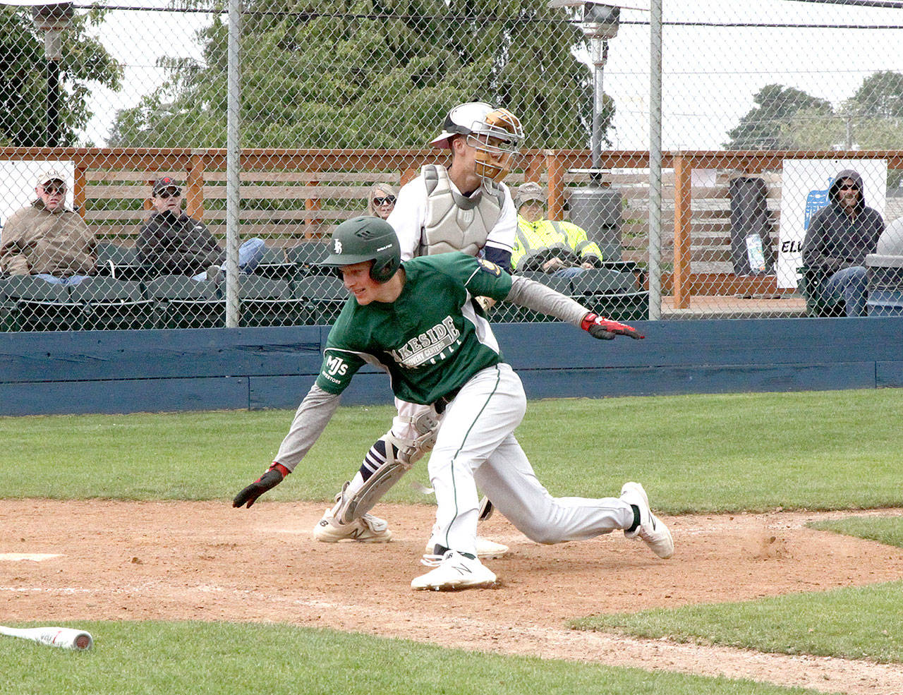 Lakesides Nate Moore tries to score around Wilder catcher Joel Wood waits with the ball in his mitt Sunday at Civic Field. Wood held onto the ball and Moore was called out. Wilder split with first-place Lakeside, losing the first game of a doubleheader 3-0, but winning the nightcap 5-4. (Dave Logan/for Peninsula Daily News)