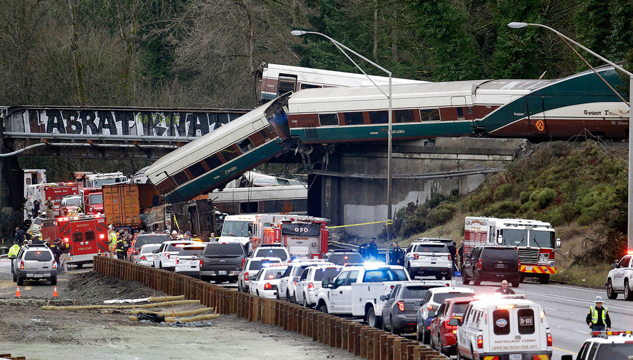 In this Dec. 18, 2017, file photo, cars from an Amtrak train lay spilled onto Interstate 5 below as some remain on the tracks above in DuPont. (Elaine Thompson/The Associated Press)