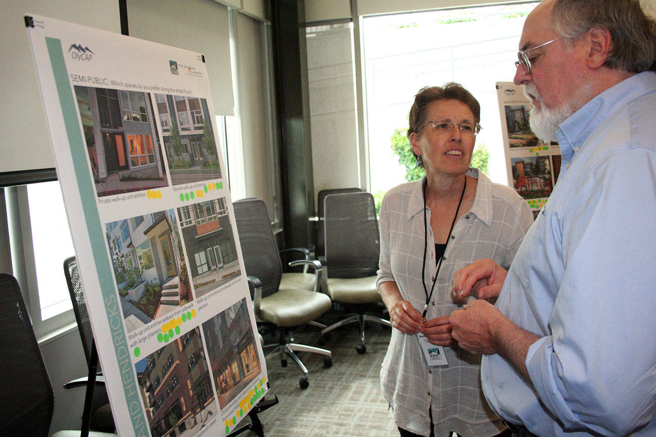 Phillipa Nye of Ally Community Development discusses several options for the Olympic Community Action Programs’ proposed 44-unit housing complex with Roy Walker of the Olympic Area Agency on Aging. About 50 people attended an open house Wednesday night in the Dirksen conference room at Jefferson Healthcare. (Brian McLean/Peninsula Daily News)