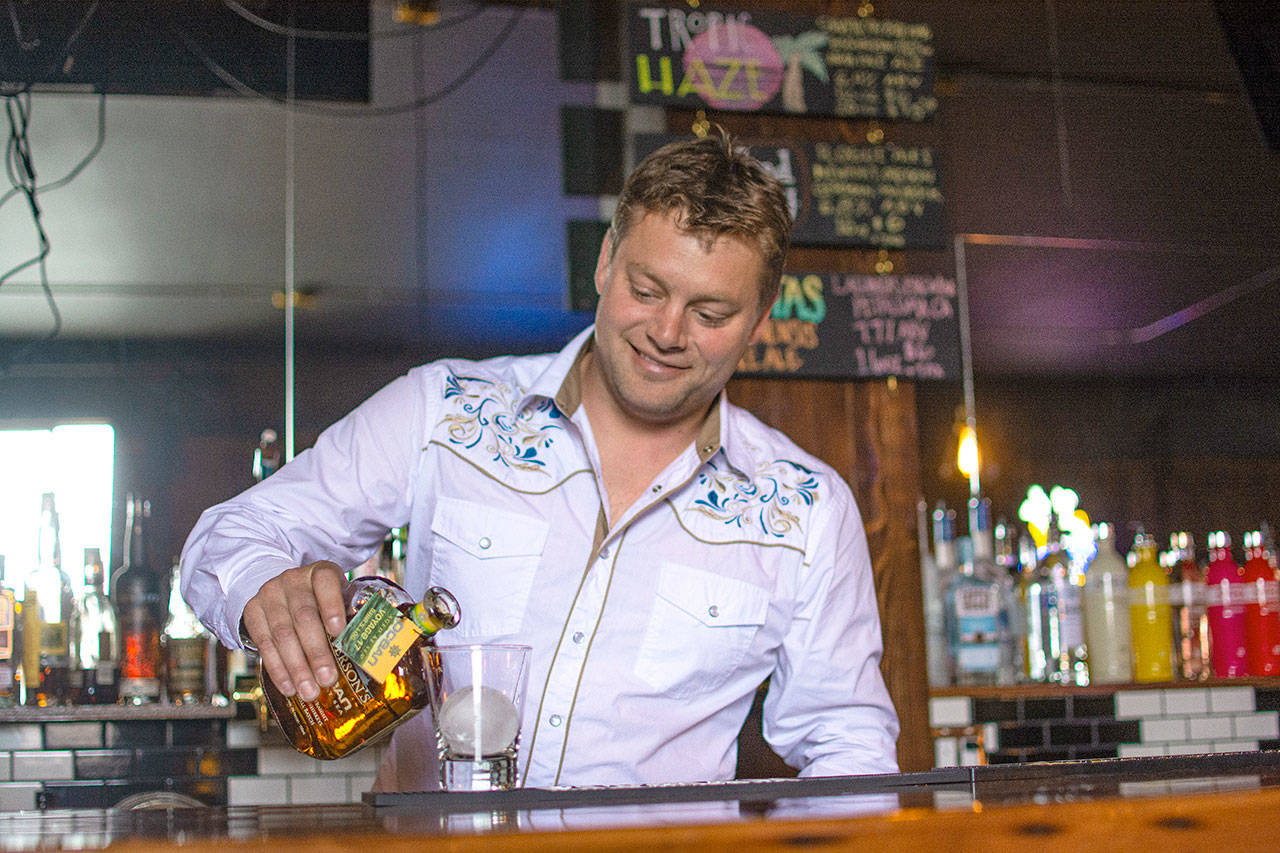 Jacob Oppelt, majority owner of Bourbon West, pours a drink during the opening of the new Port Angeles bar Thursday. (Jesse Major/Peninsula Daily News)