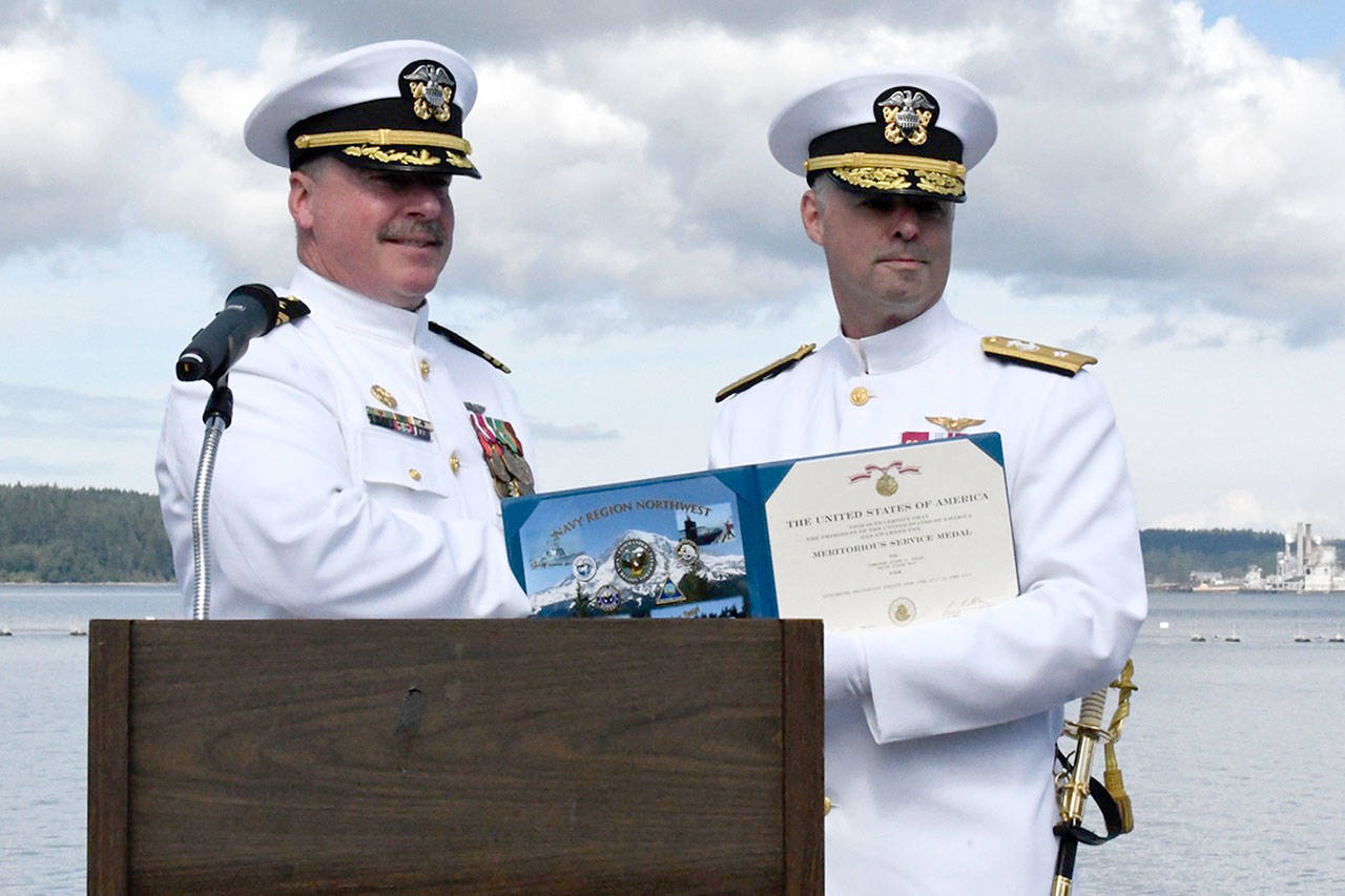 Commander Rocky Pulley, left, concluded his two-year assignment at Naval Magazine Indian Island on Friday during a change of command ceremony. He was presented a meritorious service award and gold star by Rear Admiral Scott Gray, USN commander, Navy Region Northwest on behalf of the president of the United States. (Jeannie McMacken/Peninsula Daily News)