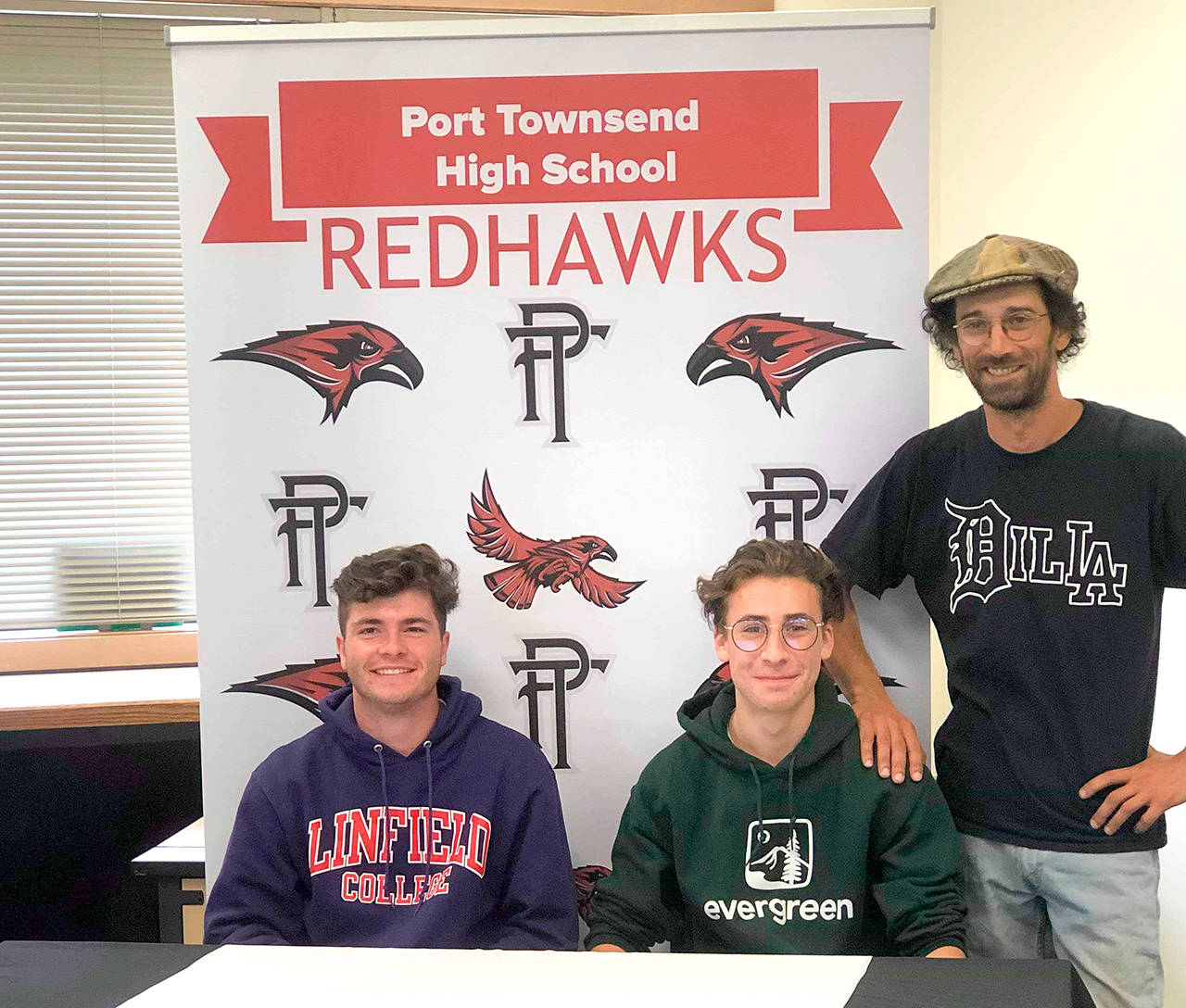 Port Townsend soccer players Zach Dempsey, left, and Owen Scanlon are joined by Redhawks head coach Robert Cantley as they sign to play college soccer. Dempsey will play for Linfield College and Scanlon for Evergreen State College.