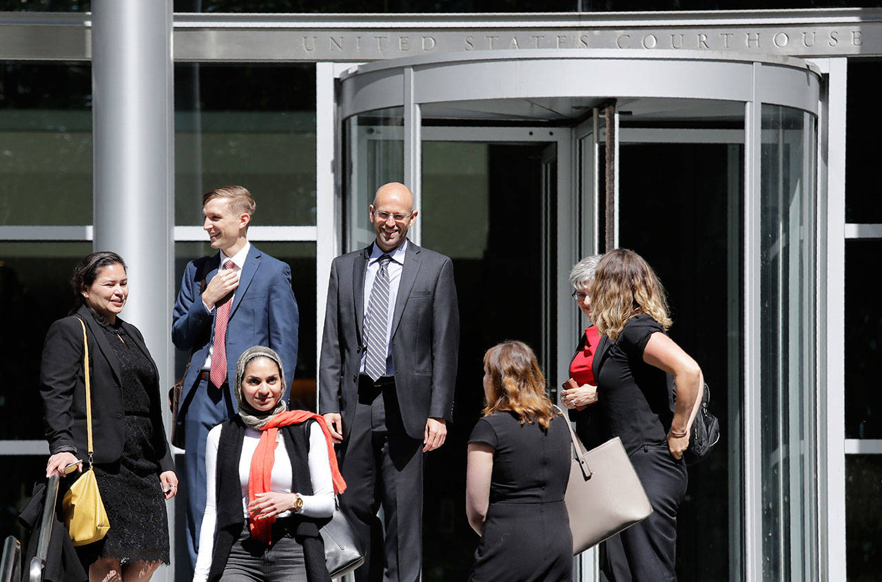 Matt Adams, center right, legal director of the Northwest Immigrant Rights Project, leaves the U.S. Courthouse with others after a hearing on asylum seekers Friday in Seattle. (Elaine Thompson/The Associated Press)