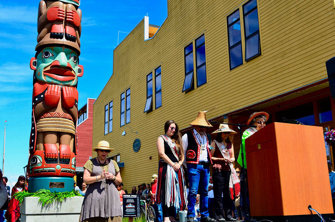 Elaine Grinnell blesses the new totem pole at the Northwest Maritime Center in Port Townsend as part of an opening ceremony for the Chetzemoka Trail. (James Cook/for Peninsula Daily News)