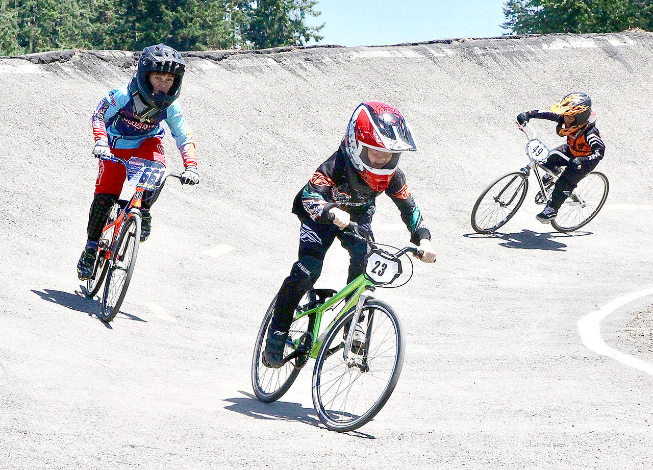 Raddick Serna (23) of Gig Harbor leads #661 Kohen Wills (661) of Puyallup in the first big curve on Sunday’s state qualifier BMX racing at Lincoln Park in Port Angeles. A total of 339 racers competed on Sunday, and more than 560 competed over the weekend. (Dave Logan/for Peninsula Daily News)