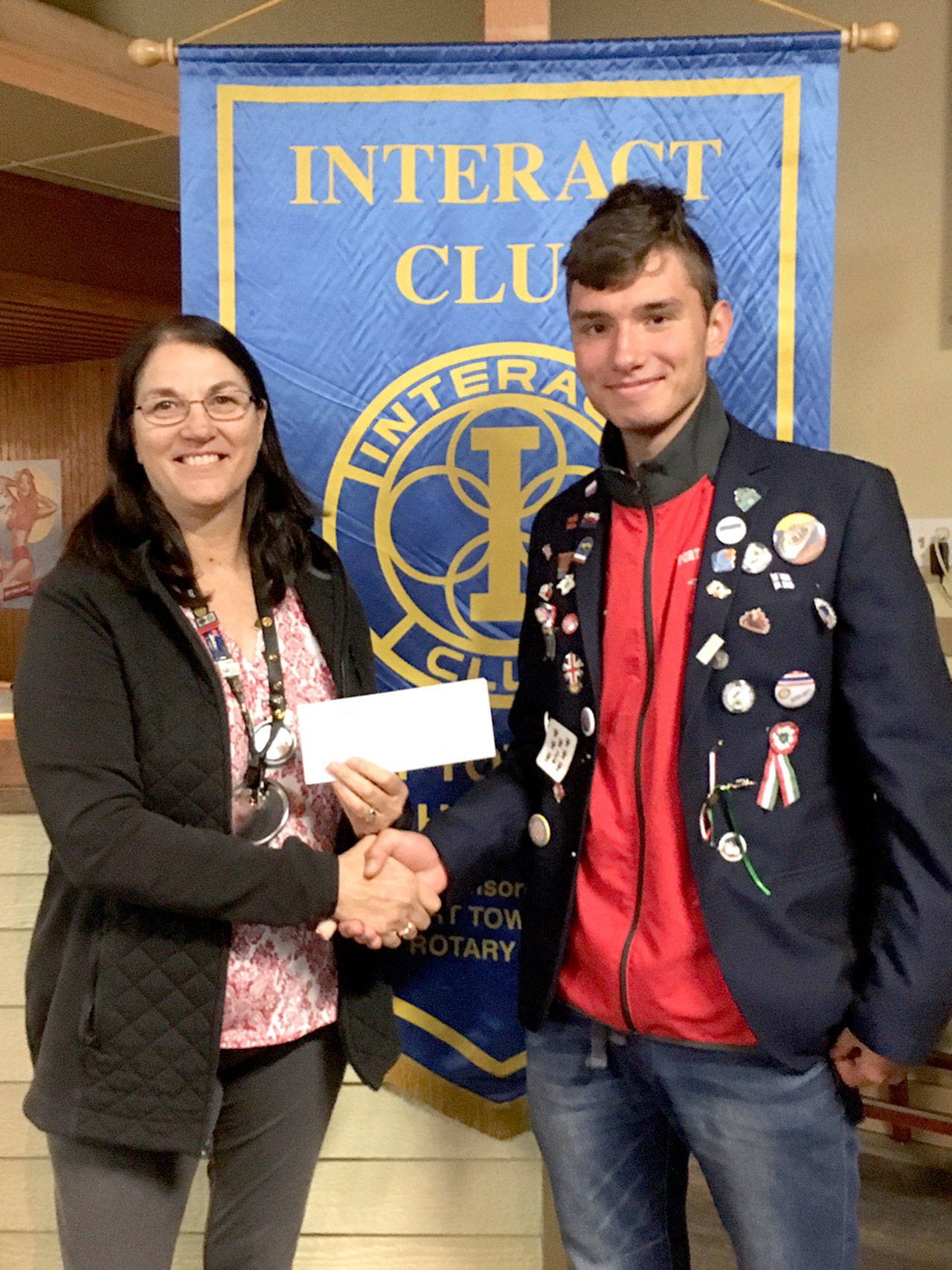 Rotary Club President Jayne Neu, left, accepts a check from Interact club member Kuba Krol, a foreign exchange student from Poland, for the Rwandan Grandmas organization.