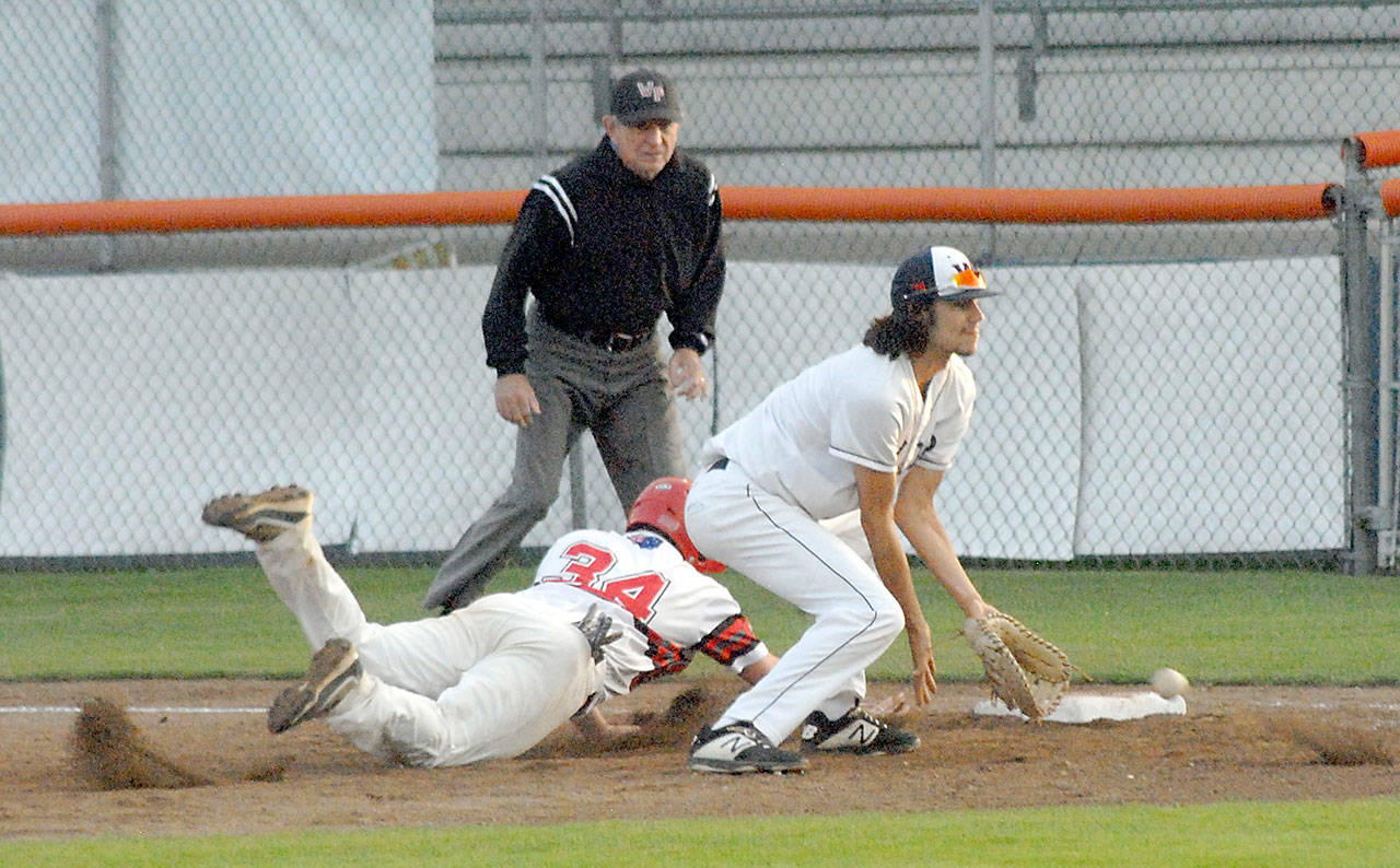 Keith Thorpe/Peninsula Daily News Wilder first baseman Bo Bradow receives a wild throw from the mound as Australia Red baserunner Ryan Hudson dives back to base during the fourth inning on Saturday night at Port Angeles Civic Field.