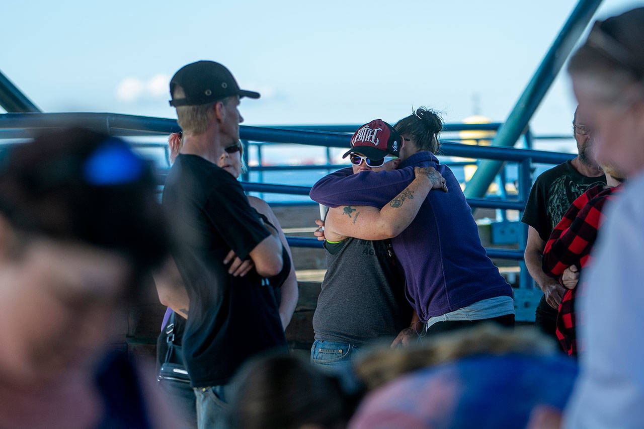 Two people embrace during a vigil for Valerie Kambeitz and her children Lilly, Emma and Jayden Kambeitz on Monday. (Jesse Major/Peninsula Daily News)
