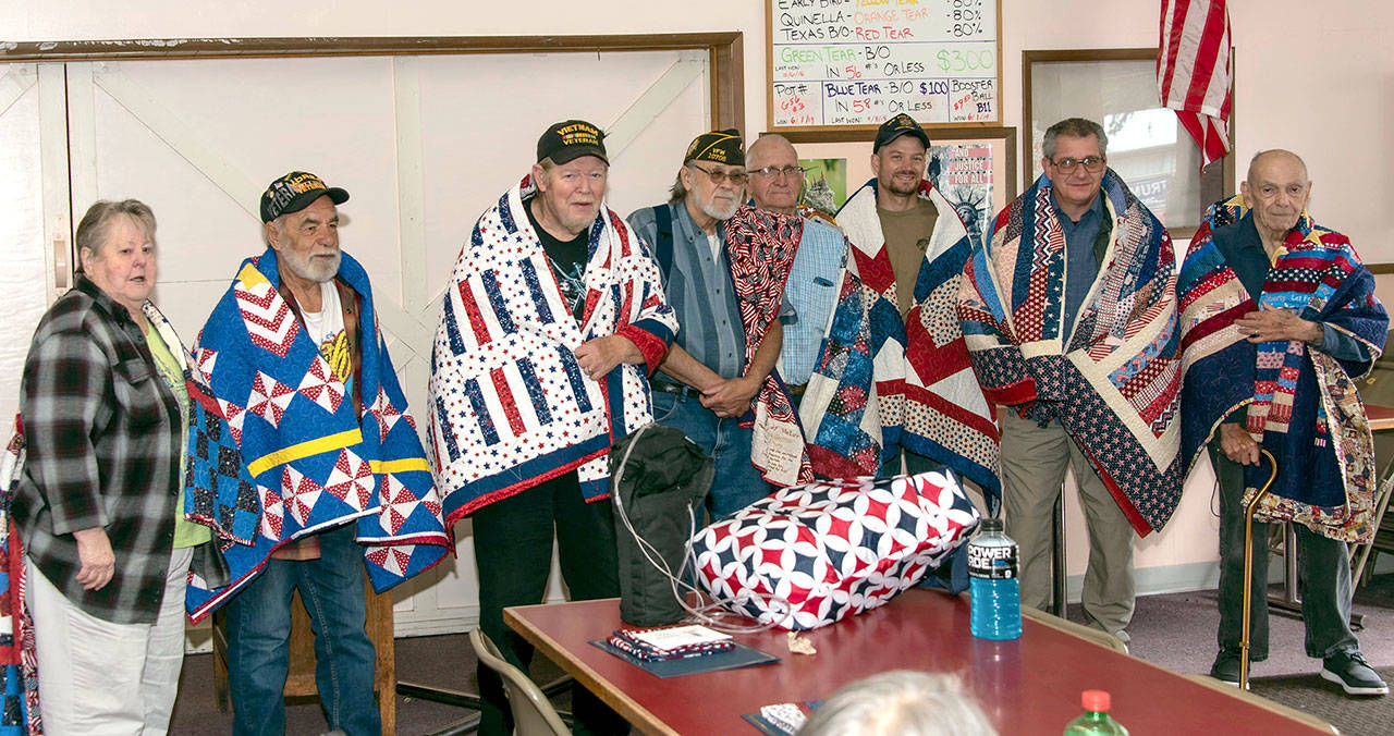 Military veterans, from left, Sherry Adcock, Larry Hartley, Gerald Maxey, Don Griffith, Ernie Muir, Ron Hough, David Garman and Ken Gaul receiving Quilts of Valor.