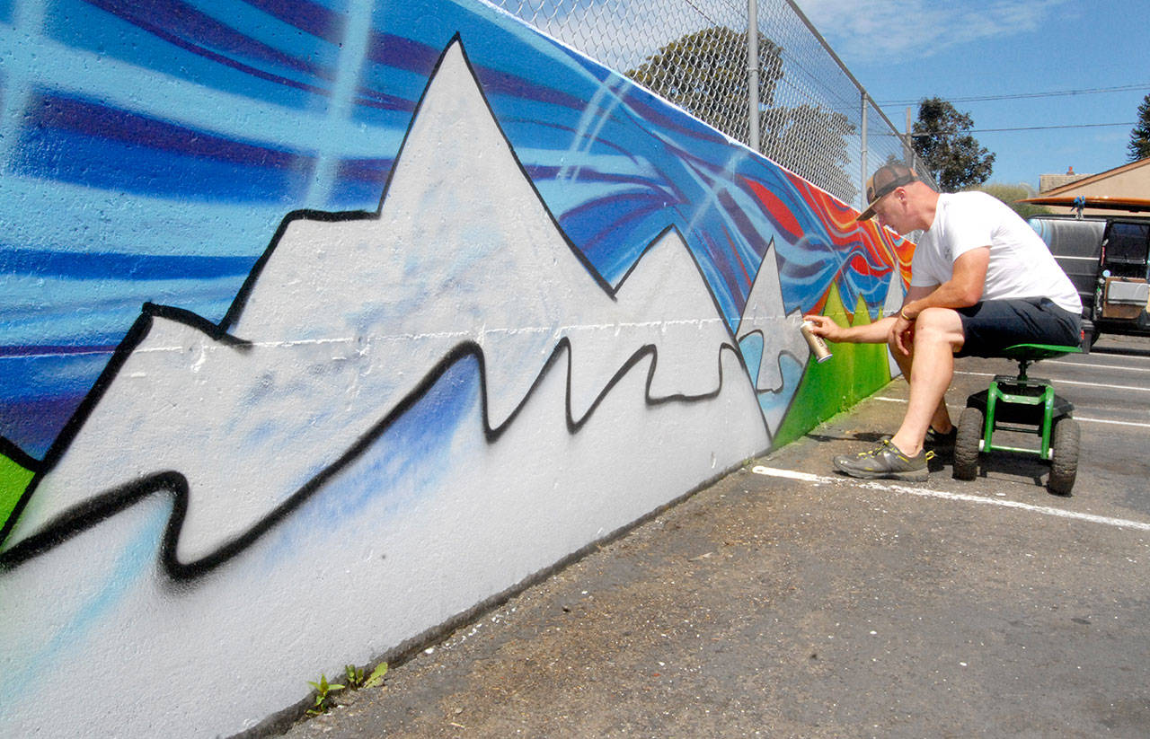 Muralist Todd Fischer adds paint Friday to a mural he is creating at the Banbury Corner Children’s Center in Port Angeles. The mural is to be dedicated to the Kambeitz family. (Keith Thorpe/Peninsula Daily News)