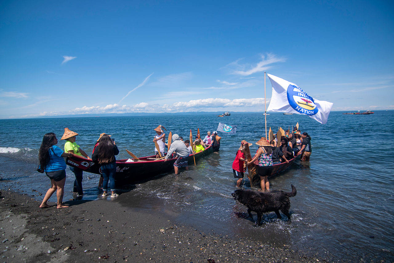 Canoes arrive at the Lower Elwha Klallam Tribe’s reservation during the Paddle to Lummi on Sunday. (Jesse Major/Peninsula Daily News)