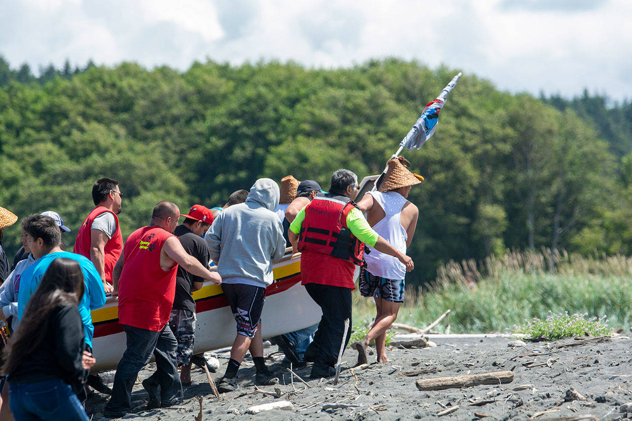 A canoe is carried onto the beach on the Lower Elwha Klallam Tribe’s reservation during the Paddle to Lummi on Sunday. (Jesse Major/Peninsula Daily News)