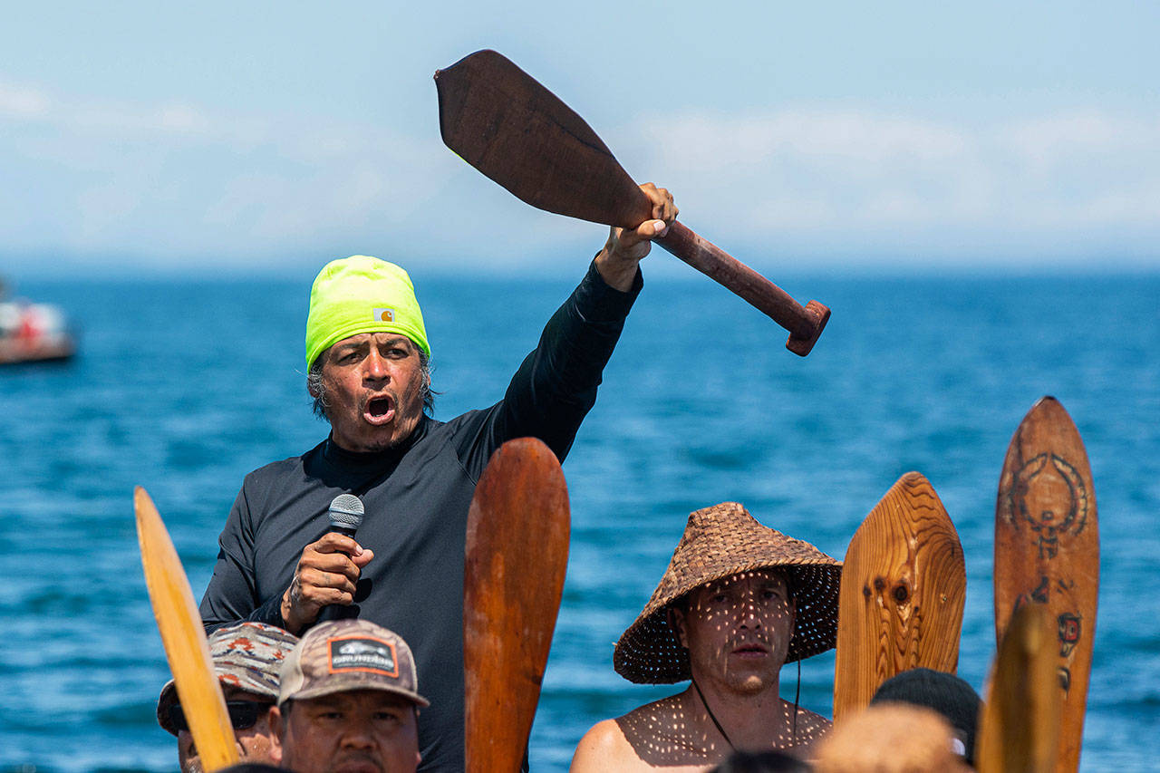 Marco Black, skipper of a canoe family from the Quinault Tribe, requests permission to land at the Lower Elwha Klallam Tribe’s reservation during the Paddle to Lummi on Sunday. (Jesse Major/Peninsula Daily News)