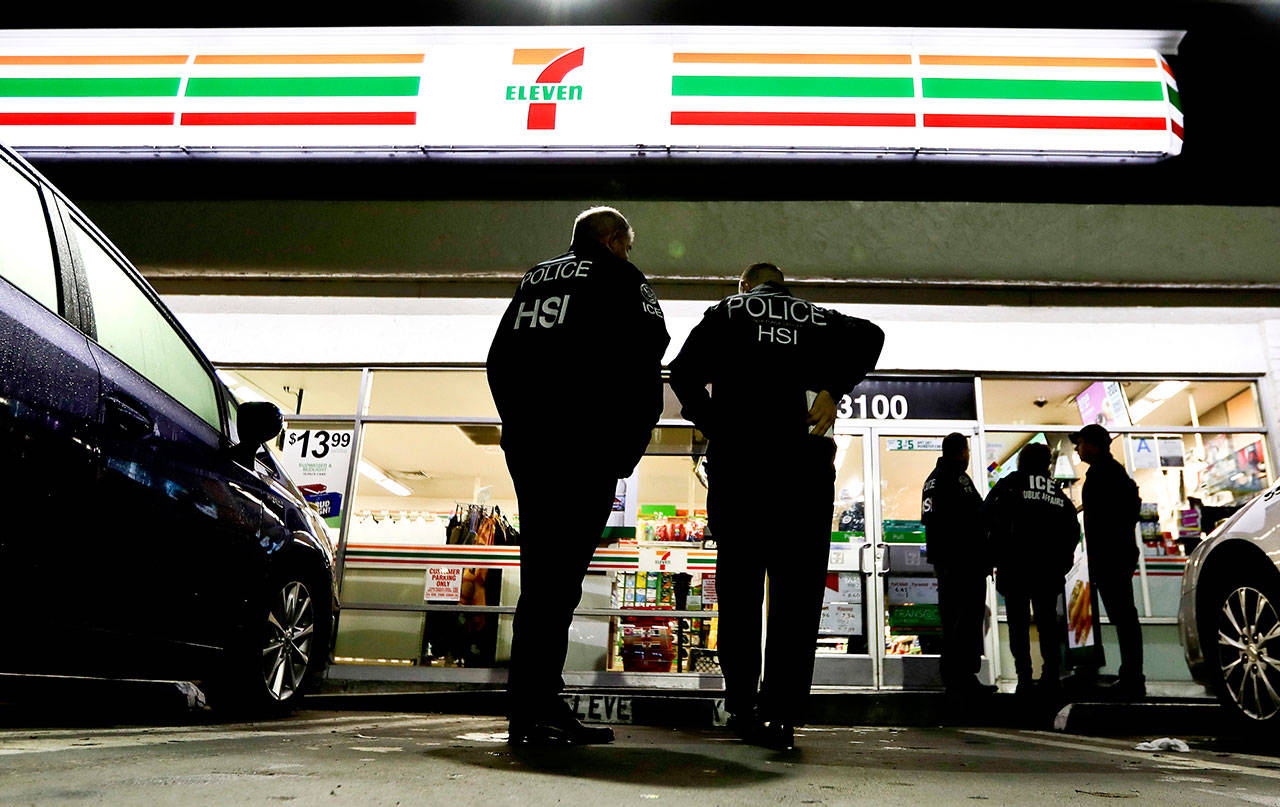 In this Jan. 10, 2018, file photo, U.S. Immigration and Customs Enforcement agents serve an employment audit notice at a 7-Eleven convenience store in Los Angeles. (Chris Carlson/The Associated Press)