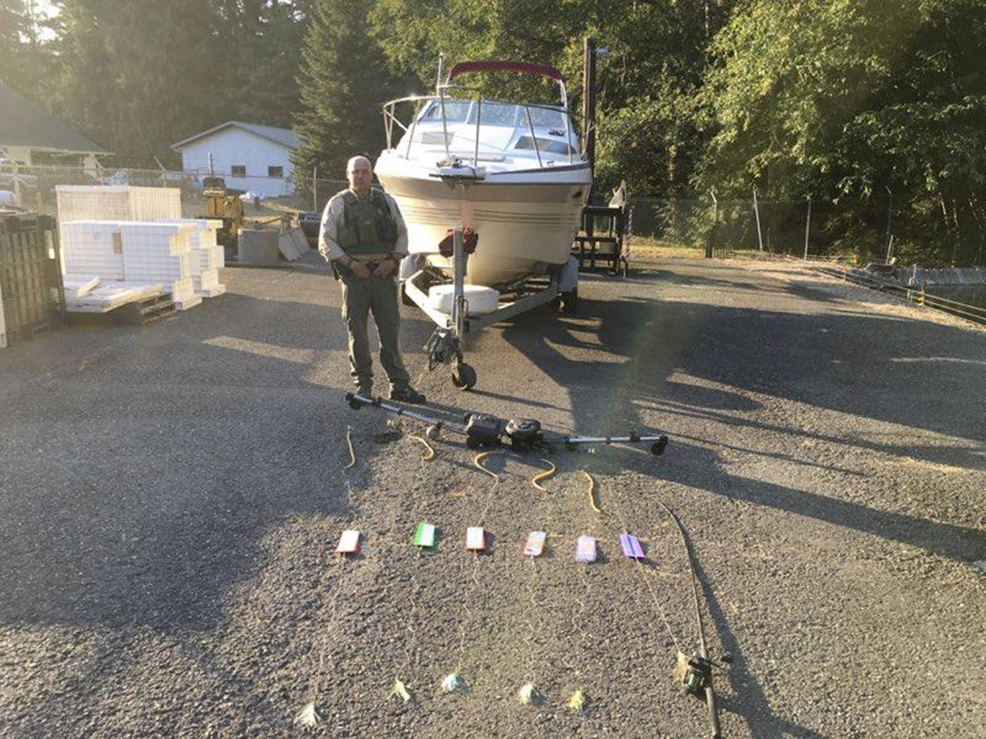 State Department of Fish and Wildlife                                 State Fish and Wildlife Officer Bryan Davidson stands behind six fishing lines seized from a salmon poacher off Sekiu last summer.