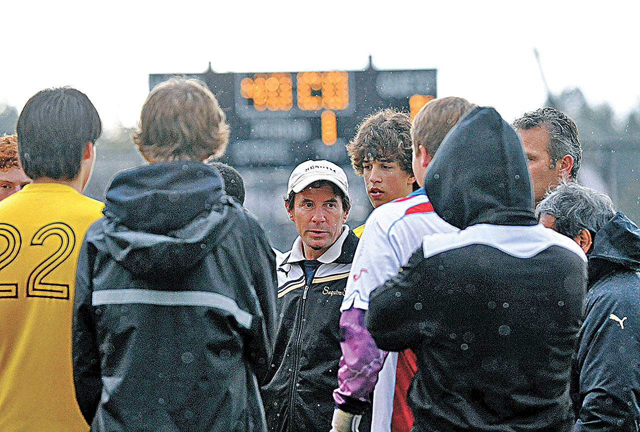 Sequim High head coach Dave Brasher, center, talks to his players in a sub-district playoff game in 2011 against Eatonville (Sequim won in overtime). Brasher is stepping down from his position after 24 years leading the varsity program. Sequim Gazette file photo by Michael Dashiell