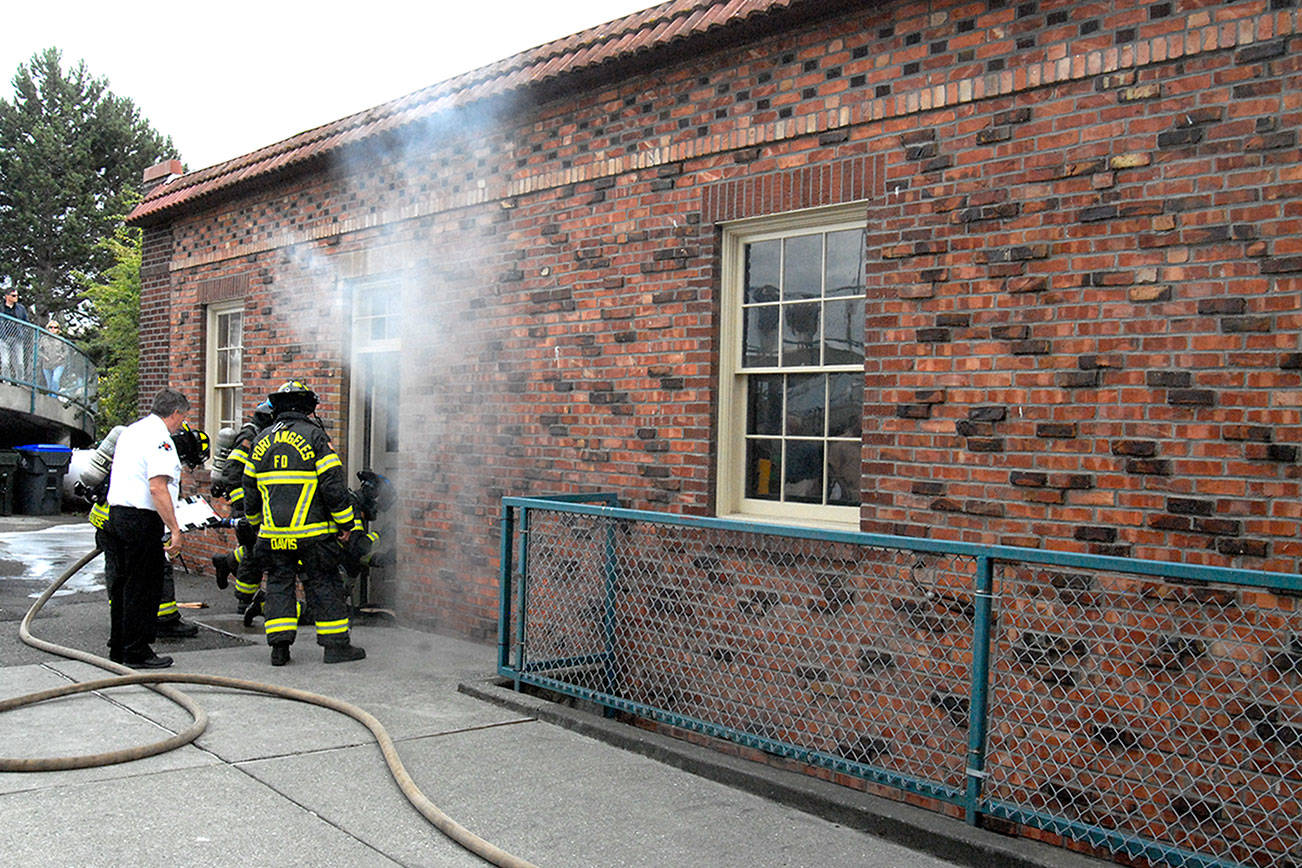PHOTO: Firefighters pull up flooring to douse fire at Port Angeles Visitor Center
