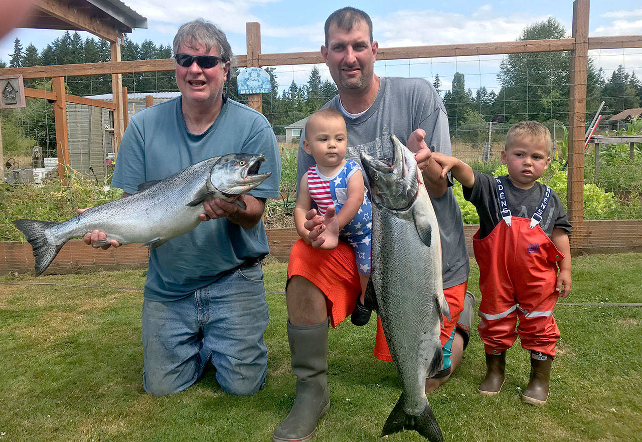 Port Angeles’ Guy Madison, left, fished with son Jon Madison (holding baby Rhys) and grandson Beau Madison (age 2 1/2) Wednesday off Ediz Hook. The Madison’s caught the 17-and 15-pound hatchery kings using hoochies in 70 feet of water. Jon and his family now live in Kenai, Alaska.