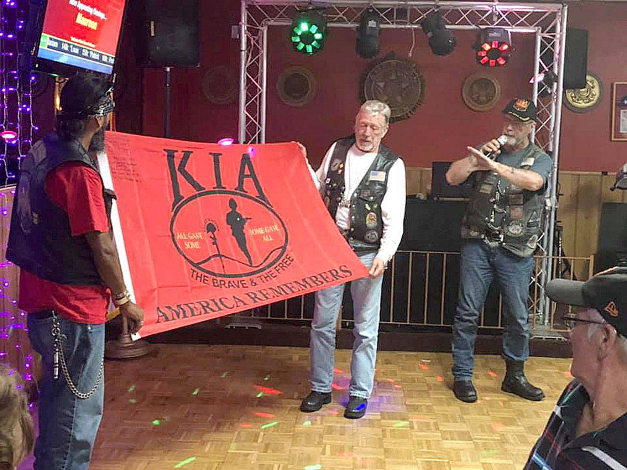 Alfredo “Go-Go” Gomez, Rick “Phin” Phinney and Hy “Crash” Libby present a KIA flag in Florida. The Epic Ride for Dignity and Remembrance riders will present a similar flag to Betsy Reed Schultz in a Saturday ceremony at the Captain Joseph House in Port Angeles.