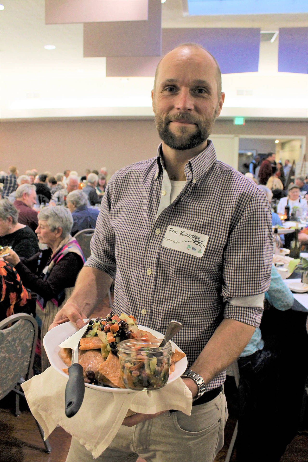 Event volunteer Erik Kingfisher carries a platter of local foods at the 2018 Friends of the Fields Harvest Dinner. (North Olympic Land Trust)
