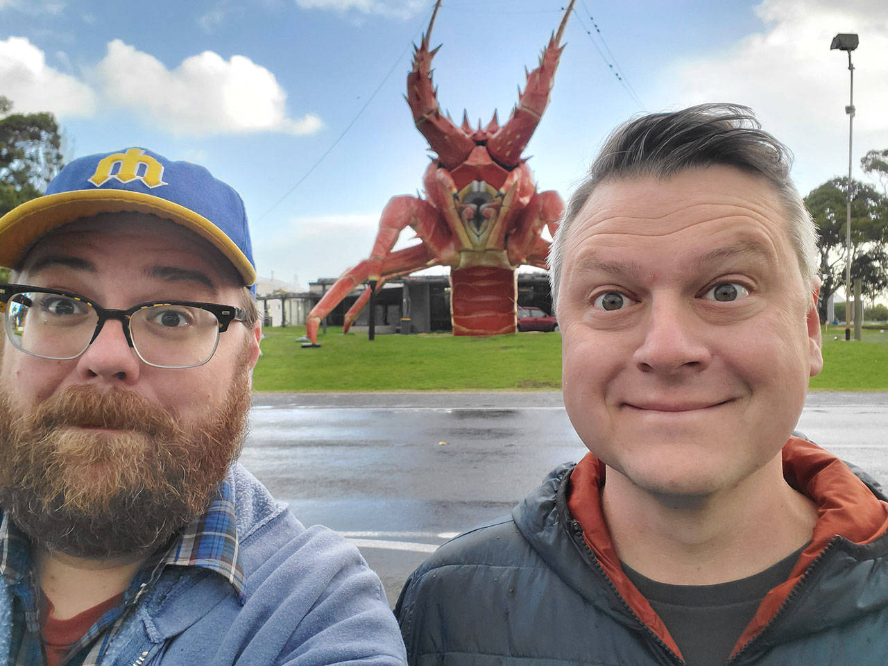 Andrew Walsh, left, and Luke Burbank, hosts of the podcast Too Beautiful to Live, visit Larry the Lobster in Kingston SE, Australia, during one of their latest adventures. The podcast is nearing its 3,000th episode and will be featured live during Thing at Fort Worden on Aug. 24 at the Wheeler Theater, where Walsh got married. (American Public Media)