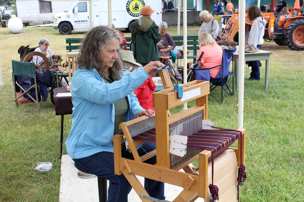Linda York works on her weaving at the Peninsula Weavers Guild and the Jefferson County Spinners booth at the Jefferson County Fair. (Zach Jablonski/Peninsula Daily News)