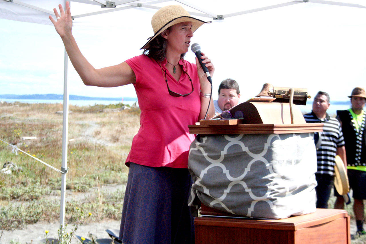 Rebecca Benjamin, executive director of the North Olympic Salmon Coalition, opens the ceremony on Isthmus Beach. Benjamin helped secure two major grants for the $12 million project that will remove the causeway and build a two-lane, 440-foot bridge to Marrowstone Island. It also includes estuary restoration for migrating salmon and tidal exchange between Oak Bay and Kilisut Harbor. (Brian McLean/Peninsula Daily News)