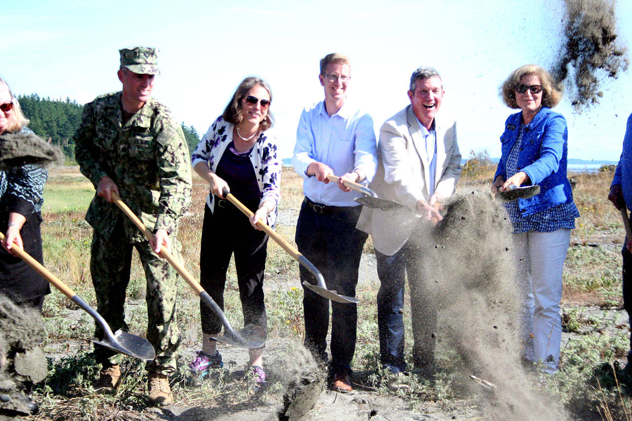 Stakeholders toss up dirt Monday during the groundbreaking ceremony for the Kilisut Harbor bridge construction and estuary restoration project. From left are Kaleen Cottingham, director of the state recreation and conservation office; Cmdr. Don Emerson, commanding officer of Naval Magazine Indian Island; Laura Blackmore, executive director of Puget Sound Partnership; U.S. Rep. Derek Kilmer, D-Gig Harbor; John Wynands, Olympic Region administrator for the state Department of Transportation; and state Sen. Christine Rolfes, D-Bainbridge Island. (Brian McLean/Peninsula Daily News)