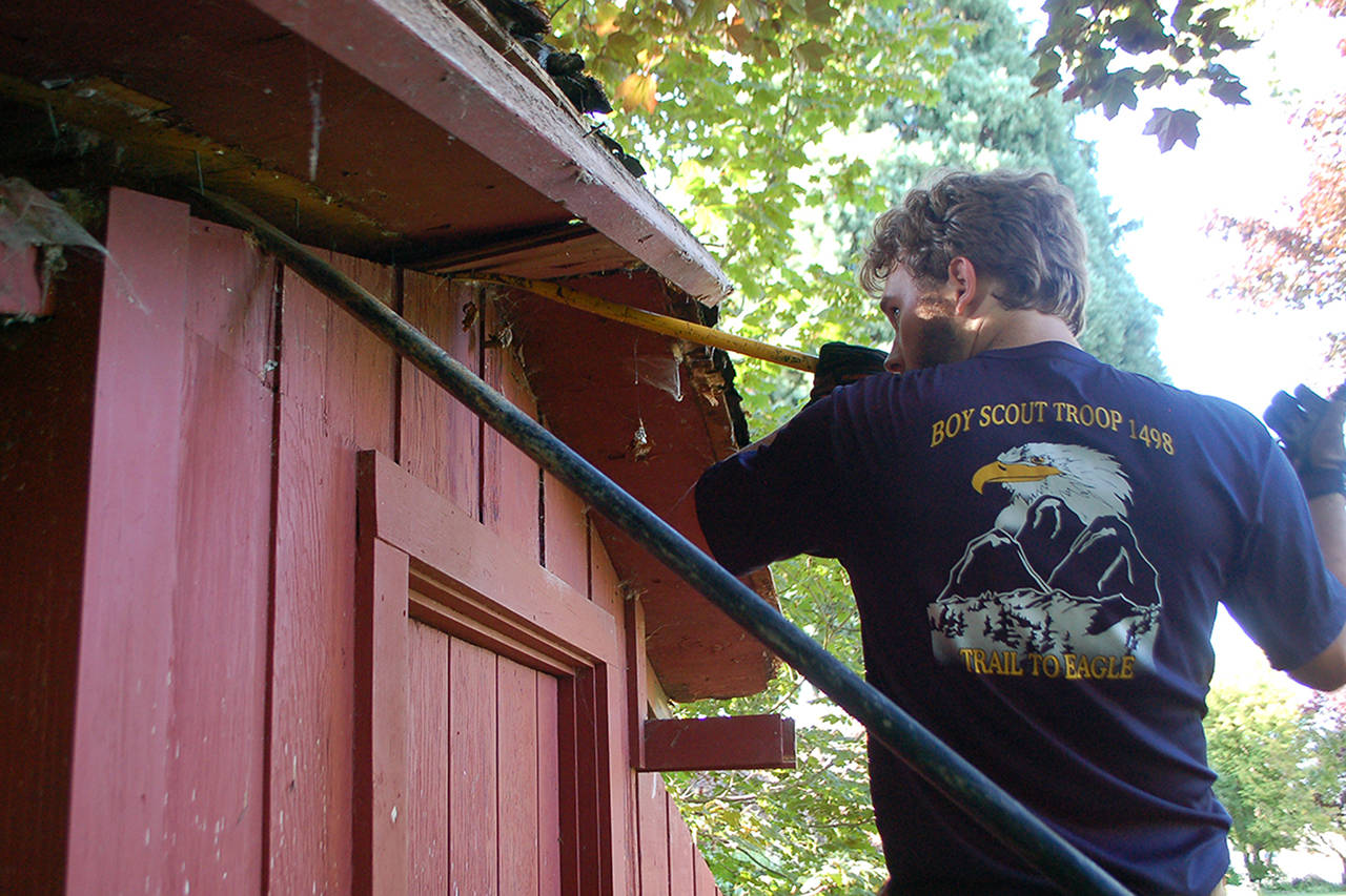 Eagle Scout candidate Ian Thill, back, and Dylan Washburn, front, lift up the first section of the Pioneer Memorial Park storage shed roof as part of Thill’s Eagle Scout project. “This roof was in worse shape than we thought,” Thill said. (Conor Dowley/Olympic Peninsula News Group)