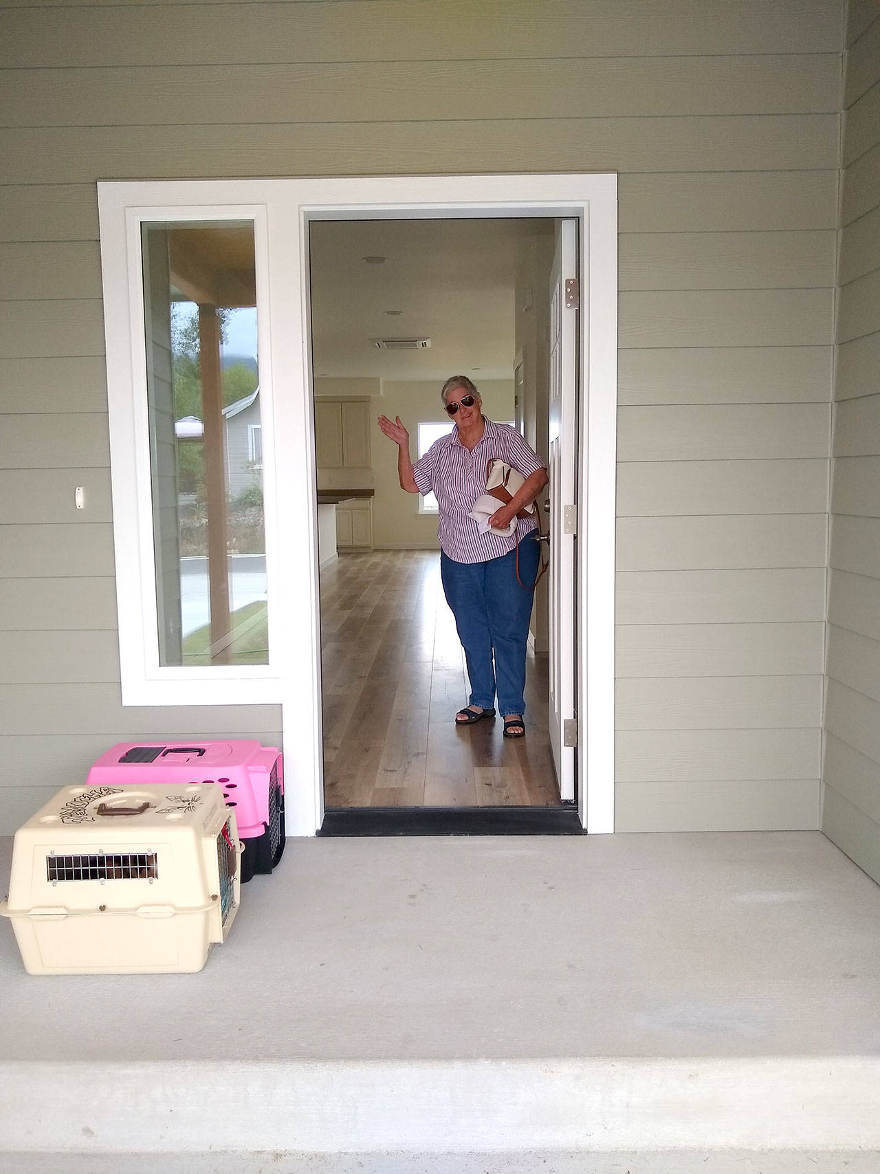 Mom takes her first steps into her new home in Port Angeles with Scamper and Simba looking on from their carriers. (Zorina Barker/for Peninsula Daily News)