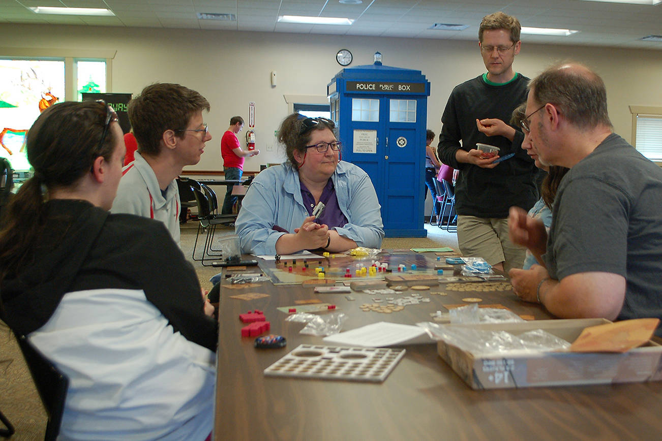 <strong>Conor Dowley</strong>/Olympic Peninsula News Group                                Several people from Sequim and Port Angeles work together to learn a new game at Opttacon 2019 at the Guy Cole Event Center.