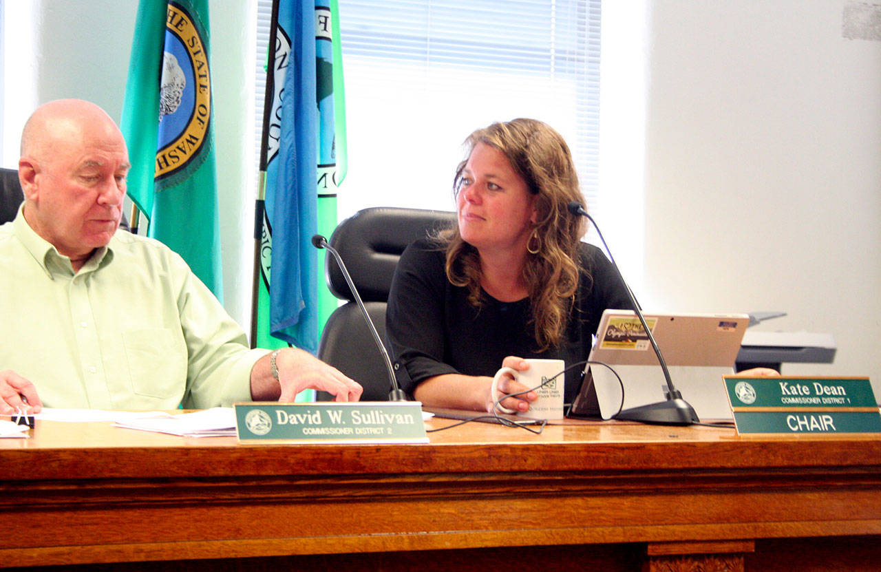 Jefferson County commissioners David Sullivan, left, and Kate Dean deliberate with Commissioner Greg Brotherton and County Administrator Philip Morley on the letter the board plans to send to Pope Resources and other government agencies regarding the recent aerial spraying of herbicides. (Brian McLean/Peninsula Daily News)