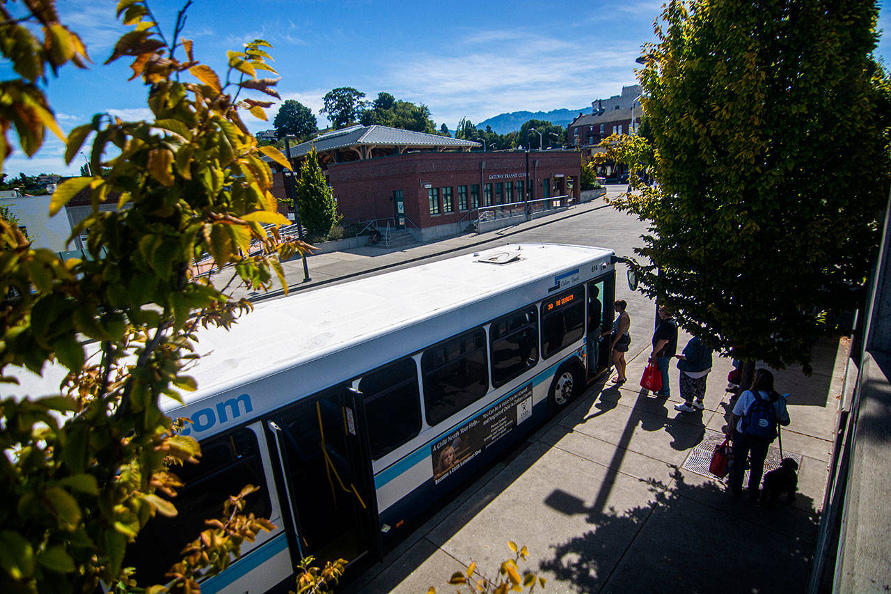 People load onto a Clallam Transit System bus at the Gateway Transit Center in Port Angeles on Wednesday afternoon. The transit board is considering whether it should remove advertising from buses. (Jesse Major/Peninsula Daily News)