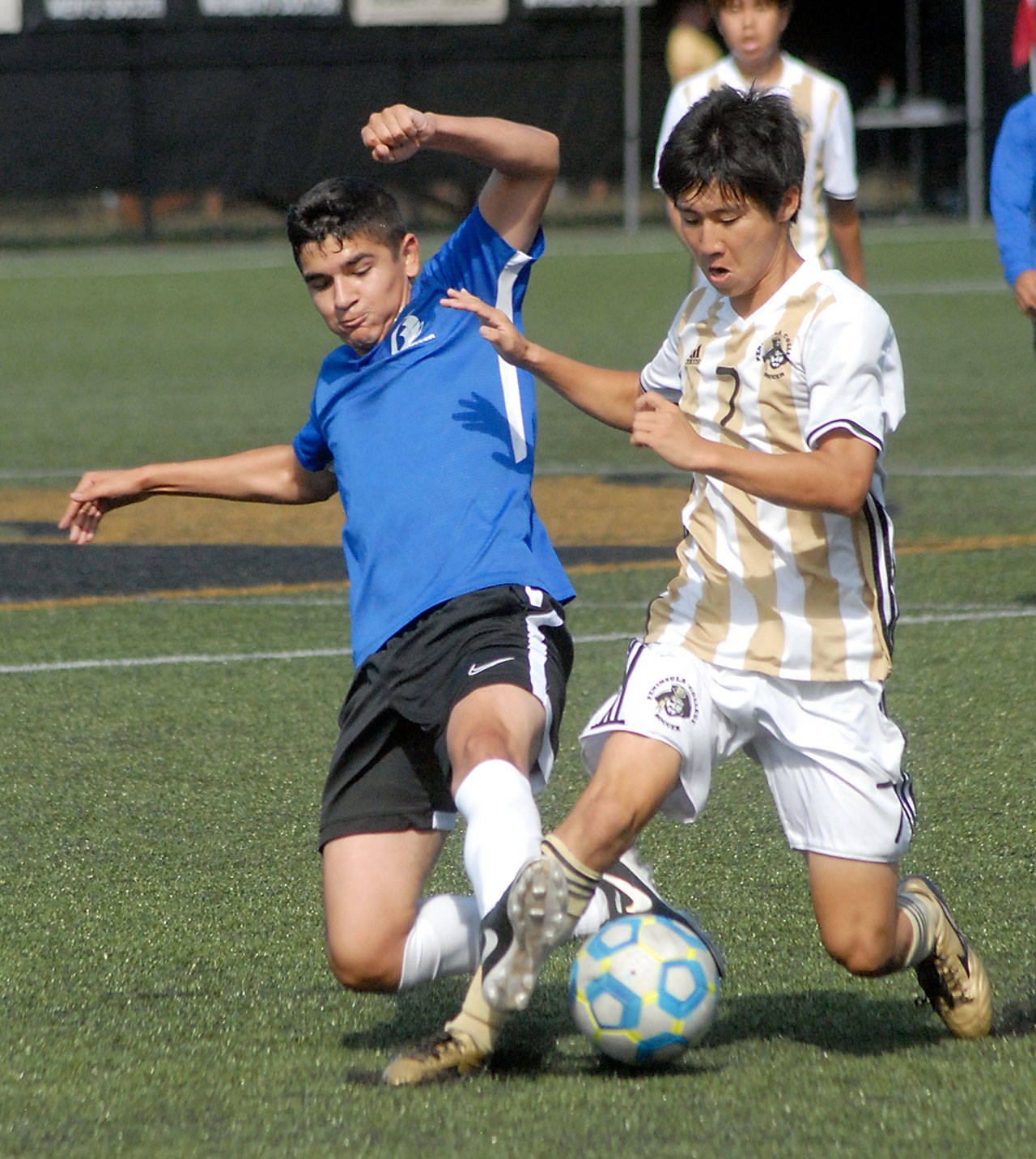 Keith Thorpe/Peninsula Daily News South Puget Sound’s Miguel Bravo, left, and Peninsula’s Hidenobu Inoue battle for ball control on Saturday in Port Angeles.