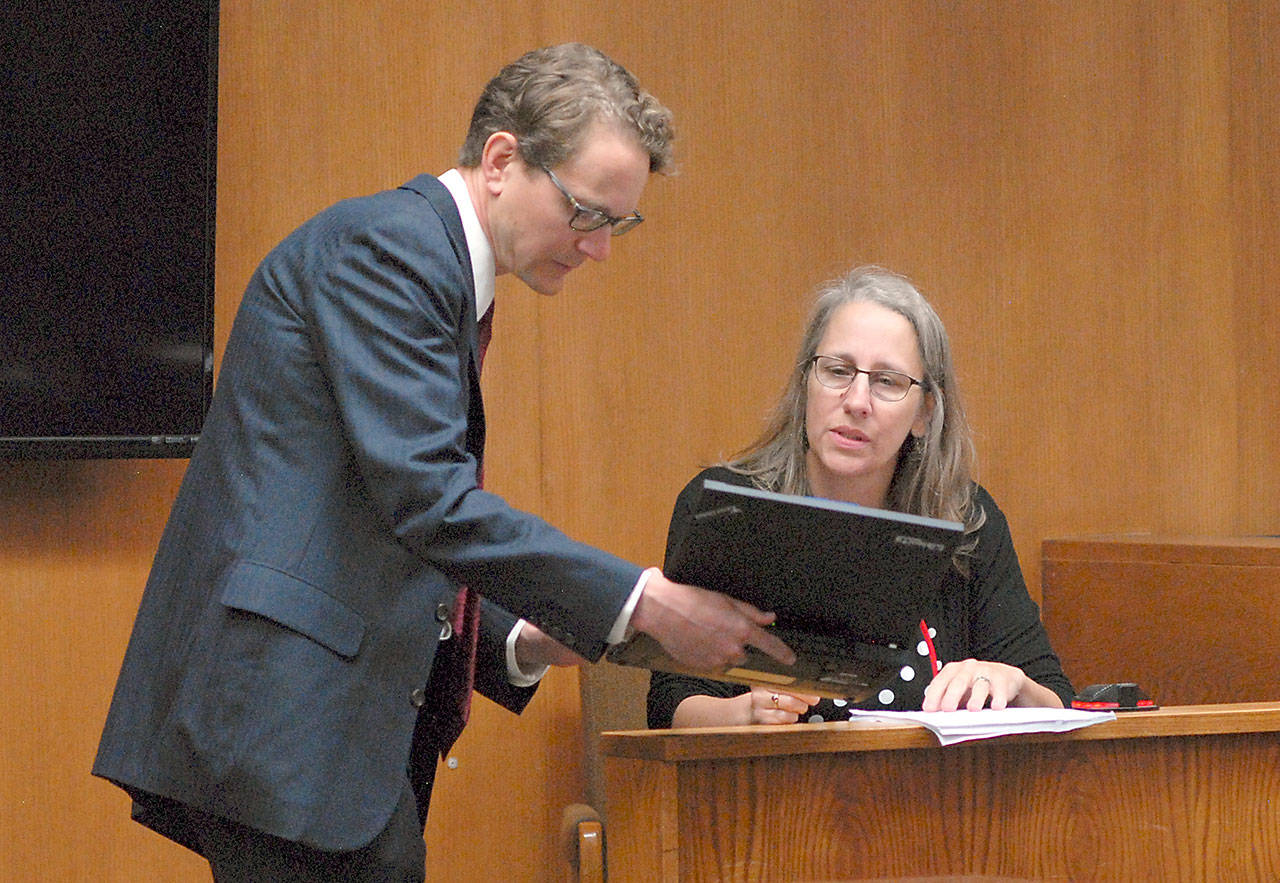 Ann Marie Henninger, a candidate for Olympic Medical Center Commissioner District No. 1, examines an electronic document displayed by Lindsey Schromen-Wawrin during cross-examination at Thursday’s Clallam County Superior Court hearing contesting Henninger’s eligibility for the position based upon her residency within the district. (Keith Thorpe/Peninsula Daily News)