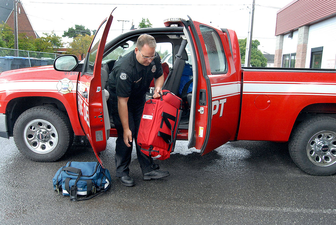 Firefighter/EMT Daniel Montana loads medical equipment in a Port Angeles Fire Department utility vehicle that he uses in place of a full-sized ambulance to cover non-emergency 9-1-1 calls. (Keith Thorpe/Peninsula Daily News)