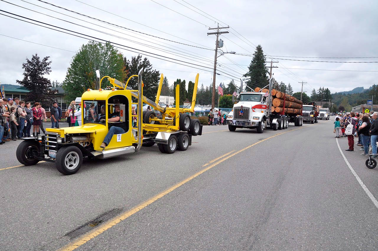 Logging trucks drive down the street during the 2018 Quilcene Parade. (Vivian Kuehl)