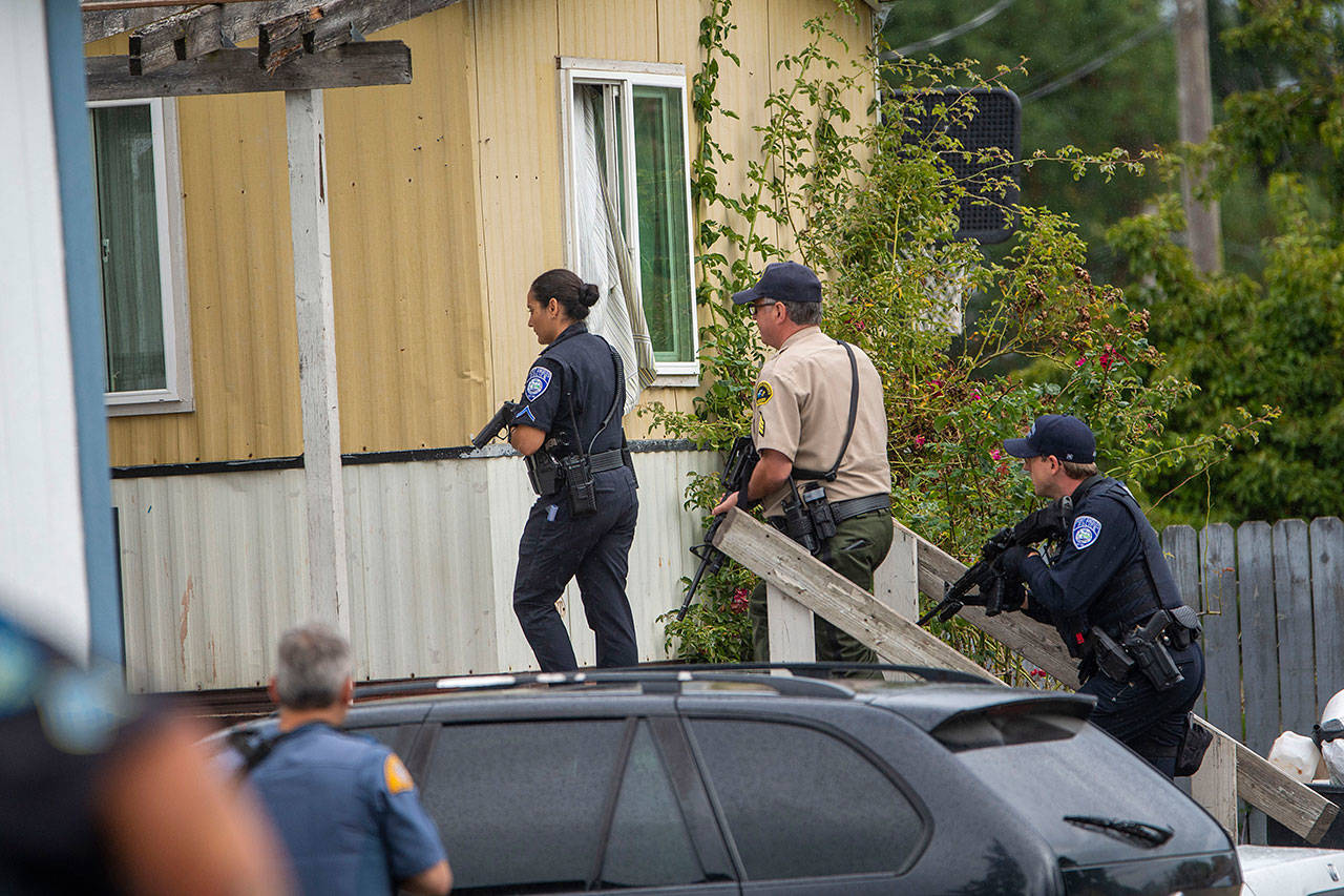 Port Angeles Police Officer Swift Sanchez, Clallam County Sheriff’s Sgt. John Hollis and Port Angeles Police Officer Luke Brown prepare to enter a trailer at the Welcome Inn RV Park in Port Angeles Thursday. (Jesse Major/Peninsula Daily News)