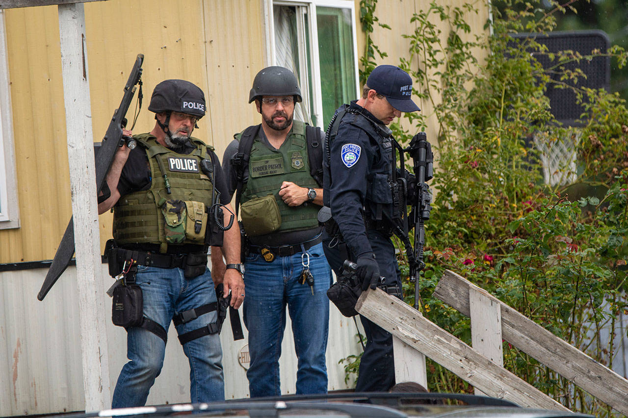 Federal and local police exit a trailer at Welcome Inn RV Park on Thursday. (Jesse Major/Peninsula Daily News)
