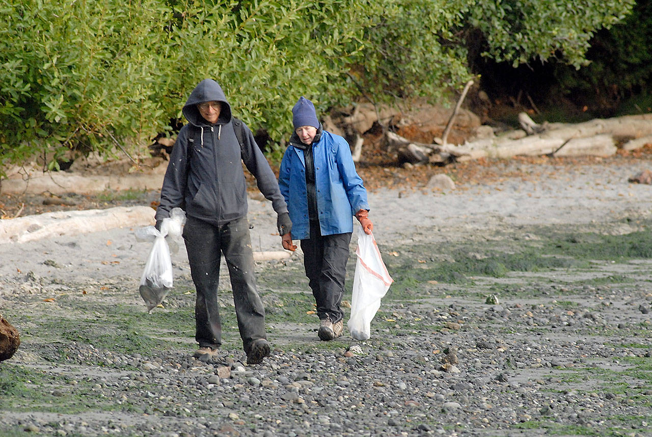 Ed Chadd, left, and Anne Dalton, both of Port Angeles, scour the beach at Freshwater Bay County Park for trash and debris during the 2017 International Coastal Cleanup. (Keith Thorpe/Peninsula Daily News)